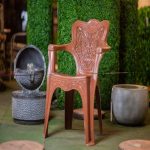 Chaise en plastique marron avec dossier haut décoré de motifs moulés.