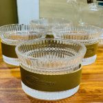 Lot de tasses en verre borosilicate strié avec manchon de protection thermique aspect cuir marron.