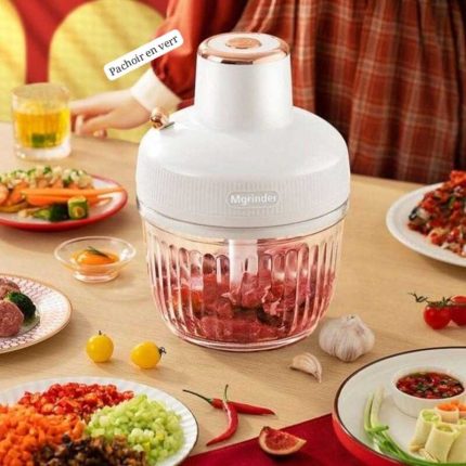 Mini hachoir électrique avec bol en verre transparent et moteur blanc contenant de la viande hachée.