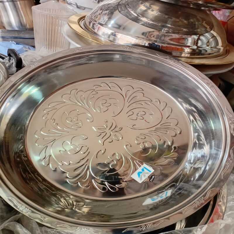 plat-service-rond-inox-motifs Grand plat de service rond en acier inoxydable avec motifs ciselés au centre