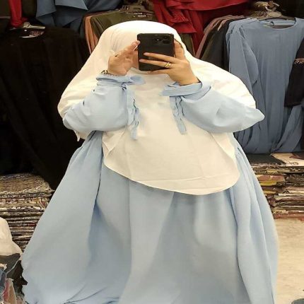 Robe longue évasée pour femme de couleur bleu roi portée avec un hijab blanc.