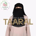 Femme portant un niqab noir fluide de chez Taaral Boutique sur une abaya rose pâle.