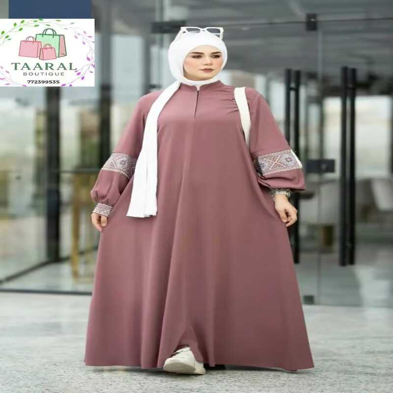 robe-abaya-brodee-vieux-rose-taaral Robe abaya évasée de couleur vieux rose avec de magnifiques détails brodés sur les manches bouffantes, portée avec un hijab blanc.