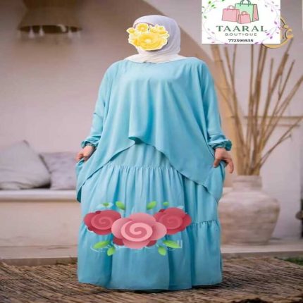 Ensemble fluide et pudique composé d'une jupe longue à étages et d'un haut très ample et asymétrique, porté avec un hijab blanc.