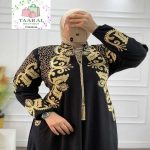 Femme prenant une photo dans un miroir, portant une djellaba royale fluide ornée de riches broderies traditionnelles et de cordons de serrage à pompons.