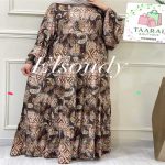 Femme portant une robe longue évasée à motifs imprimés de style ornemental et géométrique dans les tons vert, marron et beige, avec des manches longues bouffantes, par Taaral Boutique.