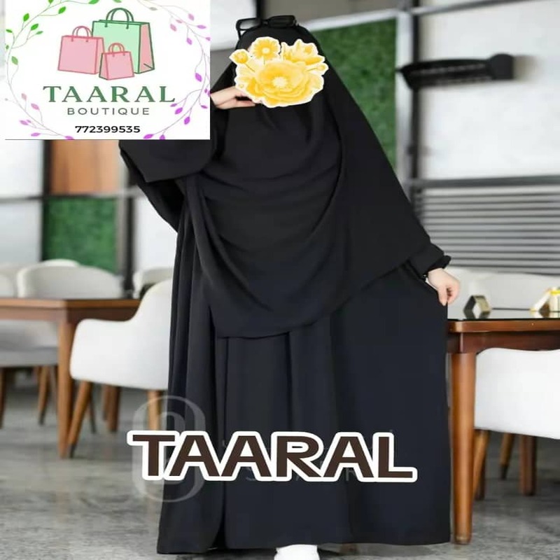 ensemble-robe-longue-khimar-noir-taaral-boutique Femme portant un ensemble deux pièces de couleur noire composé d'une robe longue fluide et d'un grand khimar assorti couvrant parfaitement le buste et les bras, proposé par Taaral Boutique.