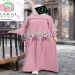 : Femme portant une abaya longue noire plissée avec manches bouffantes, style moderne et pudique.