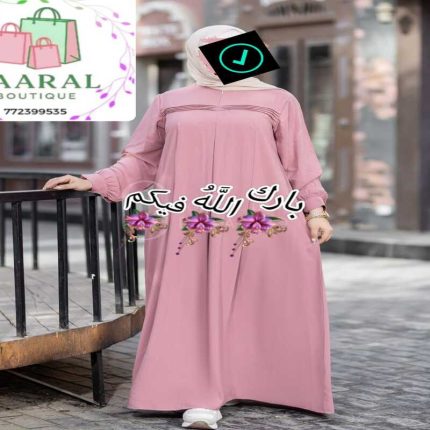 : Femme portant une abaya longue noire plissée avec manches bouffantes, style moderne et pudique.