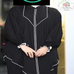 Zoom sur une abaya coupe papillon ample avec fermeture éclair à l'avant, finitions liserés contrastés et poignets élastiques froncés.
