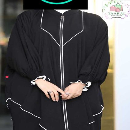 Zoom sur une abaya coupe papillon ample avec fermeture éclair à l'avant, finitions liserés contrastés et poignets élastiques froncés.