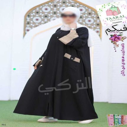 Femme portant une abaya moderne avec boutons sur le buste, revers de manches contrastés et grandes poches à l'avant.