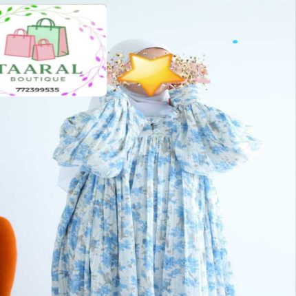 Femme portant une robe longue ample à motifs, dotée d'un col boutonné, de fronces sur le buste et de manches bouffantes élastiques.