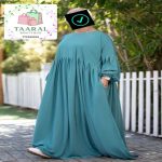 Femme portant une robe longue ample et plissée avec des manches bouffantes élastiquées, de la boutique Taaral Boutique.