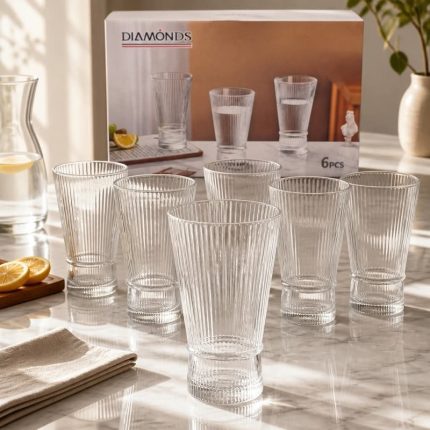 Lot de six grands verres à eau transparents au design strié vertical et base resserrée, disposés sur une table en marbre lumineuse devant leur boîte de la marque Diamonds.