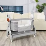 Berceau cododo évolutif pour bébé monté sur roulettes avec une paroi latérale abaissable pour lit parental, installé dans un salon moderne.