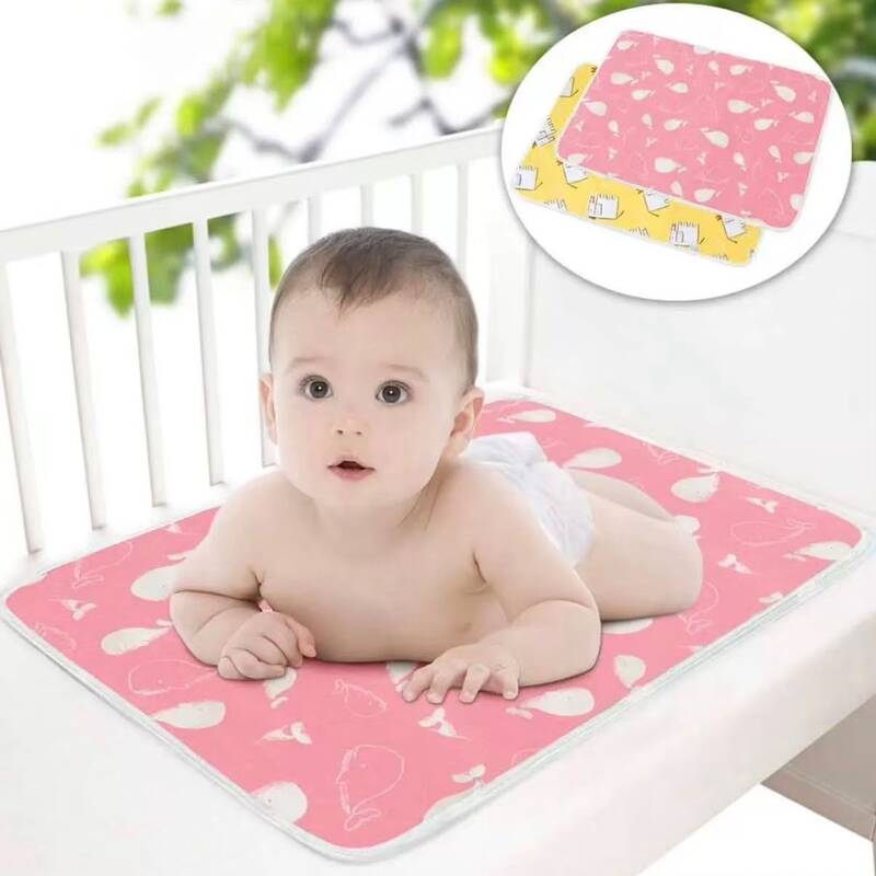 alese-impermeable-protection-lit-bebe Bébé allongé sur le ventre sur une alèse imperméable imprimée posée dans un berceau, avec un médaillon en haut à droite montrant deux tapis de protection pliés.