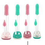 Quatre ensembles de kits de nettoyage pour biberons alignés, comprenant chacun une grande brosse en silicone, un petit goupillon pour tétine, une tige métallique fine et un socle de rangement assorti.