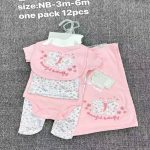 Ensemble de vêtements et accessoires en coton pour bébé présenté sur un fond gris, comprenant un body, un bavoir et d'autres pièces assorties avec de jolis motifs de girafes.