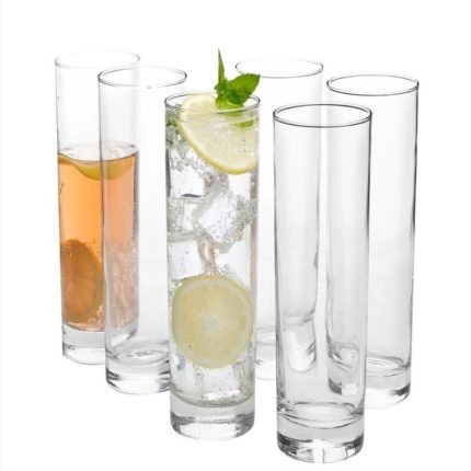 Lot de six verres hauts et cylindriques transparents, l'un contenant de l'eau gazeuse avec des glaçons, des rondelles de citron et de la menthe, un autre contenant un liquide ambré, et les autres vides sur fond blanc.