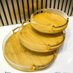 Ensemble de trois plateaux de service ronds de tailles différentes, empilés les uns sur les autres, dotés de rebords décoratifs striés et de poignées métalliques élégantes.