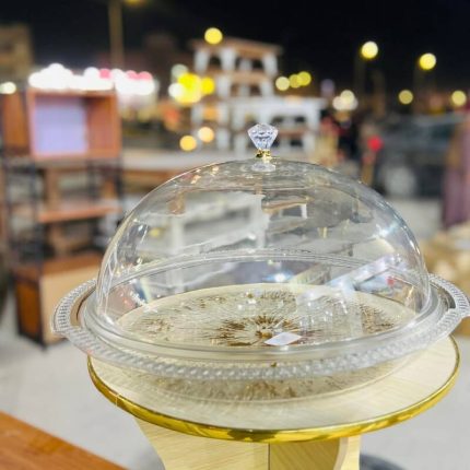 Plat de présentation rond avec sa cloche transparente bombée et poignée aspect diamant pour gâteaux et pâtisseries.