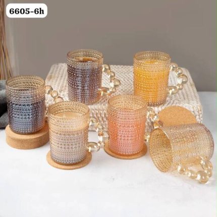 Ensemble de tasses en verre soufflé de couleur ambre dorée, posées sur de petits socles individuels circulaires en bois clair.