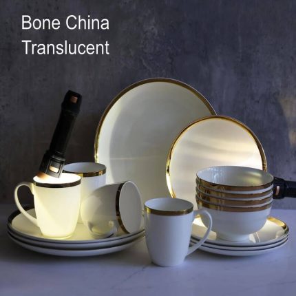 Collection de vaisselle de luxe en porcelaine blanche éclatante comprenant des assiettes de différentes tailles et des tasses, toutes finies par un liseré doré brillant sur les bords.