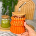 Verre à cocktail strié texturé avec couvercle en bambou et paille réutilisable.