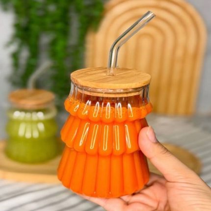 Verre à cocktail strié texturé avec couvercle en bambou et paille réutilisable.