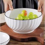 Grand bol en céramique texturé avec motifs striés pour les fruits ou la salade.