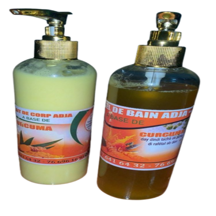 Deux flacons de Bain Adja à base de curcuma avec pompe dorée pour le soin et l'hydratation de la peau.