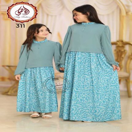 Deux jeunes filles portant une longue robe égyptienne bleu turquoise en soie et crêpe avec un haut uni à manches longues et une jupe à motifs abstraits.